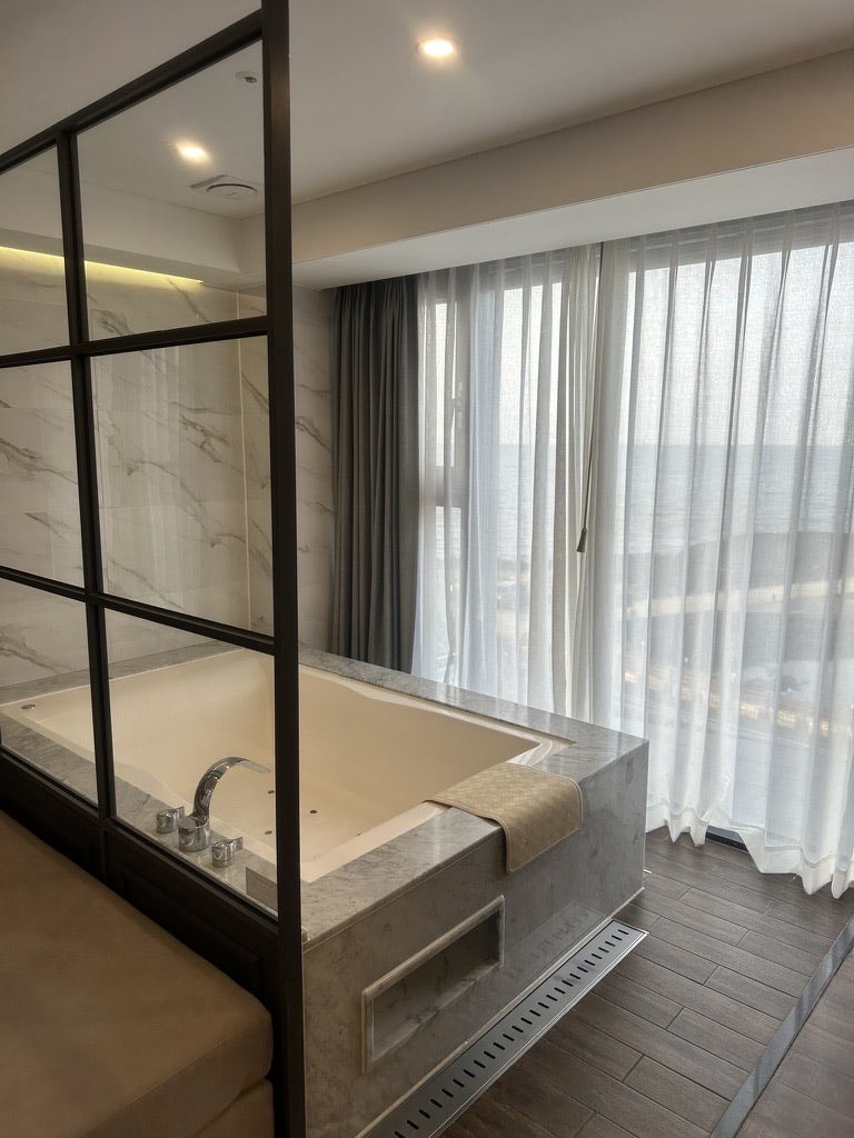 Large jacuzzi bathtub placed in front of the window in the Suite Ocean room at Dyne Oceano Hotel
