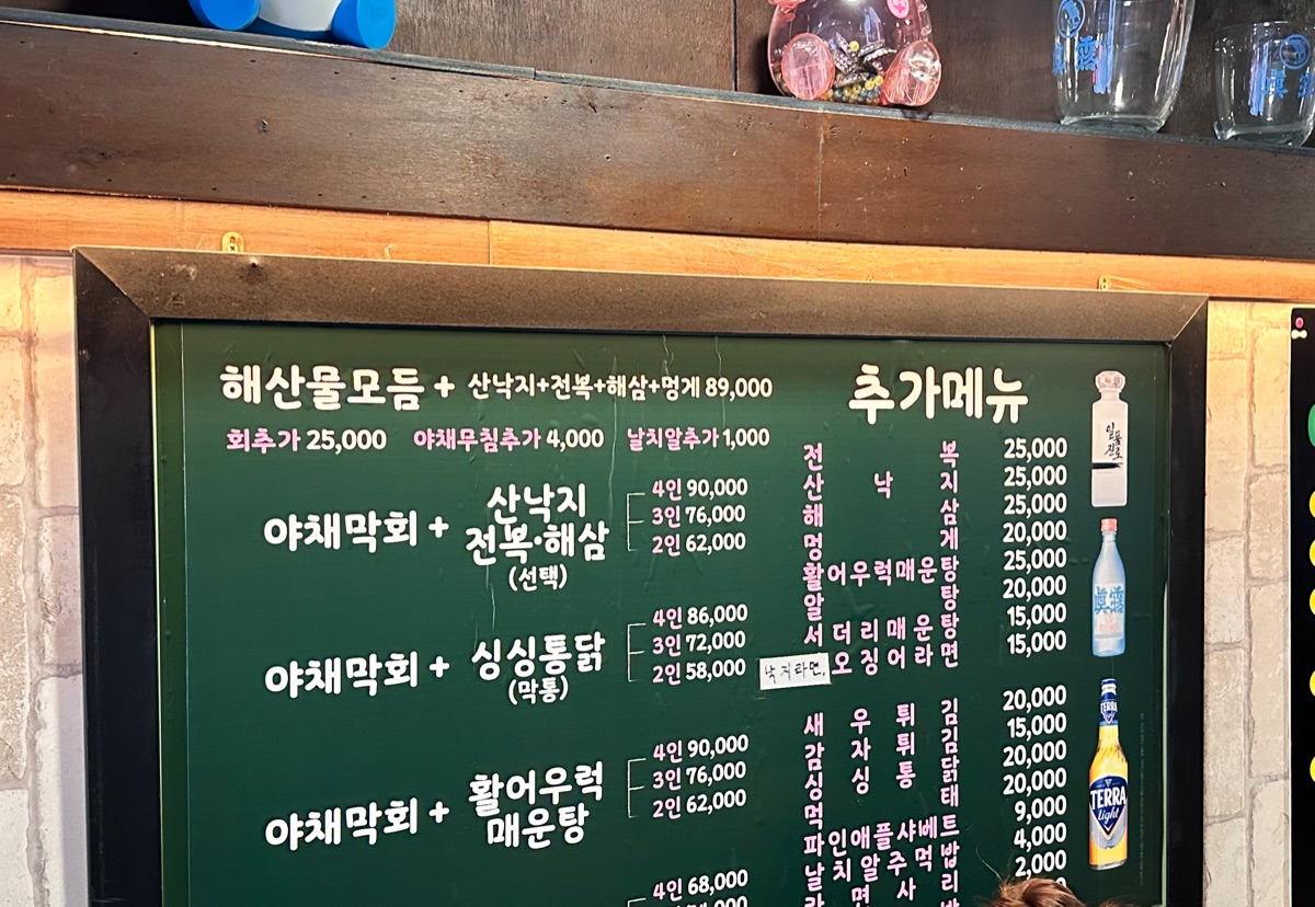 Menu board at Singsingi Yachae Makhoe listing the sashimi and fried chicken set from KRW 58,000 for two